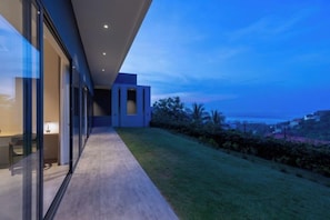 A modern building with a glass facade, a covered walkway, and a view of the landscape. - THE GREEN LOTUS SAMUI (Koh Samui)