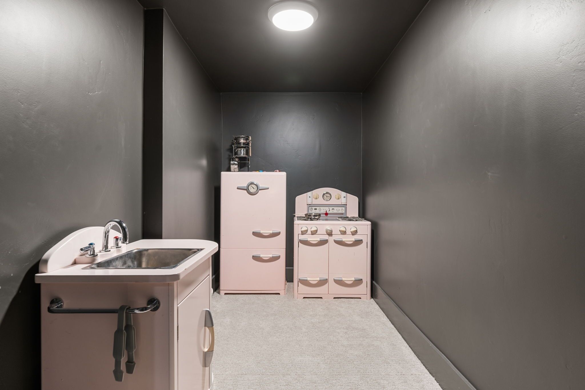 A compact kitchen with a sink, a small refrigerator, and a stove.