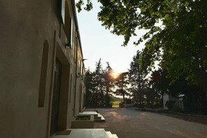 Een gebouw met een overdekte doorgang en uitzicht op de zonsondergang.