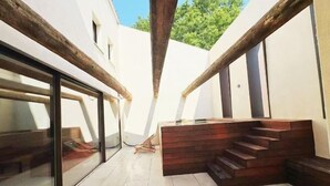 Een modern interieur met een houten trap, een glazen deur en een witte muur.