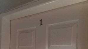 A white door with a number '1' above it, indicating it is the first door in a series.
