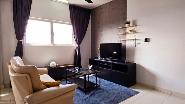 A modern living room with a beige sofa, a black entertainment unit, and a large window with curtains. - KLIA Sepang Alanis Comfort One Bed Room Unit (Sepang)