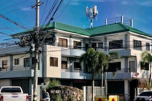 A multi-story building with a green roof, palm trees, and a sign that reads 'MOHLER HOUSE.' - Cranberry's 2Br Unit nr Convention Center #1 (Iloilo City)