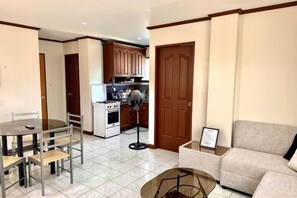 A compact living space with a dining area, kitchenette, and a sofa.