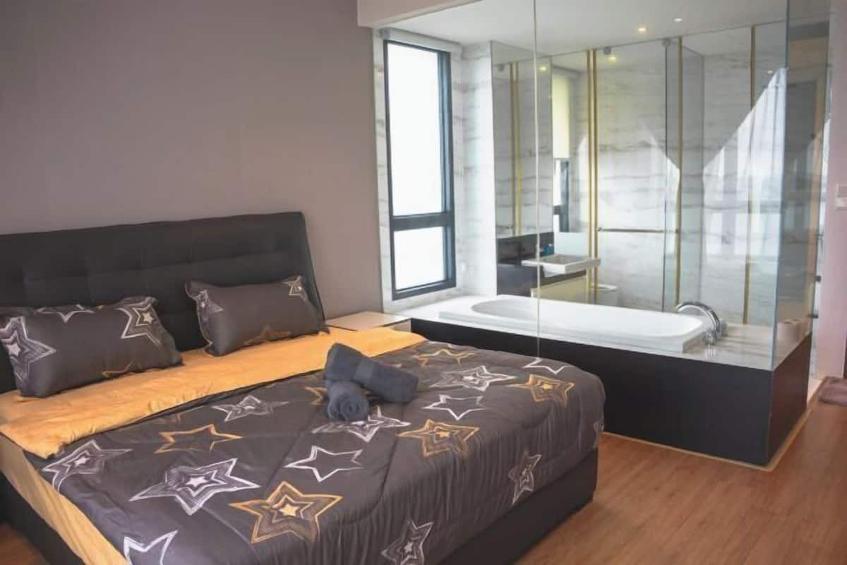Une chambre moderne avec un grand lit, une baignoire intégrée et une grande fenêtre.