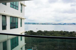 A high-rise building with a view of a body of water and a distant cityscape. - The Marina View Johor Bahru (Plentong)