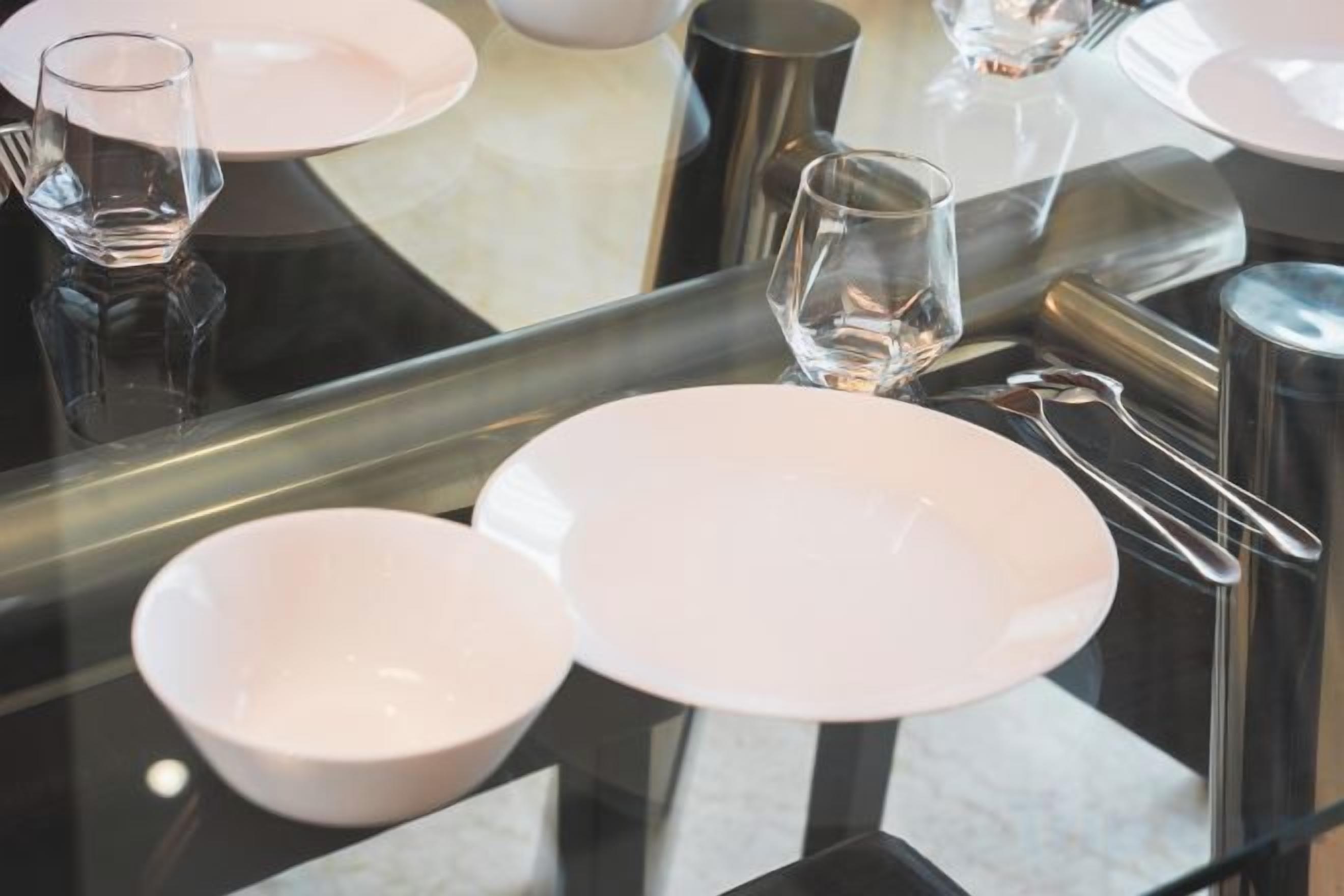 A dining table with plates, glasses, and cutlery.