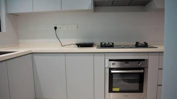 A kitchen with a built-in oven, a stovetop, and a wall-mounted exhaust hood.