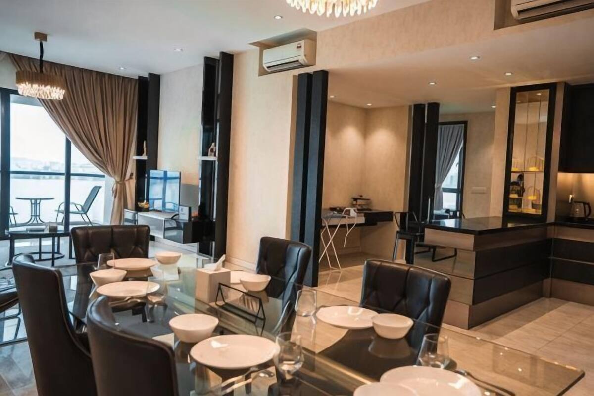 Un espace repas moderne avec une table en verre, des chaises noires et une vue sur la ville.