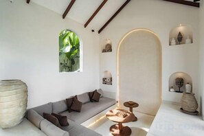 Un intérieur moderne avec un canapé, une table ronde et des objets décoratifs.