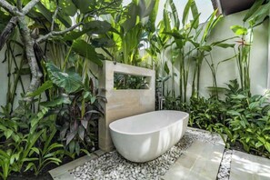 Una bañera independiente en un exuberante jardín.