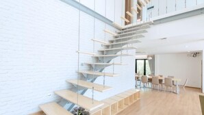 A modern interior with a staircase, wooden flooring, and a dining area. - Minimalist 4BR Private Cozy Pool Villa - VVP26.11 (Pattaya)