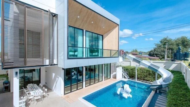 A modern house with a swimming pool, a slide, and a patio area. - Minimalist 4BR Private Cozy Pool Villa - VVP26.11 (Pattaya)