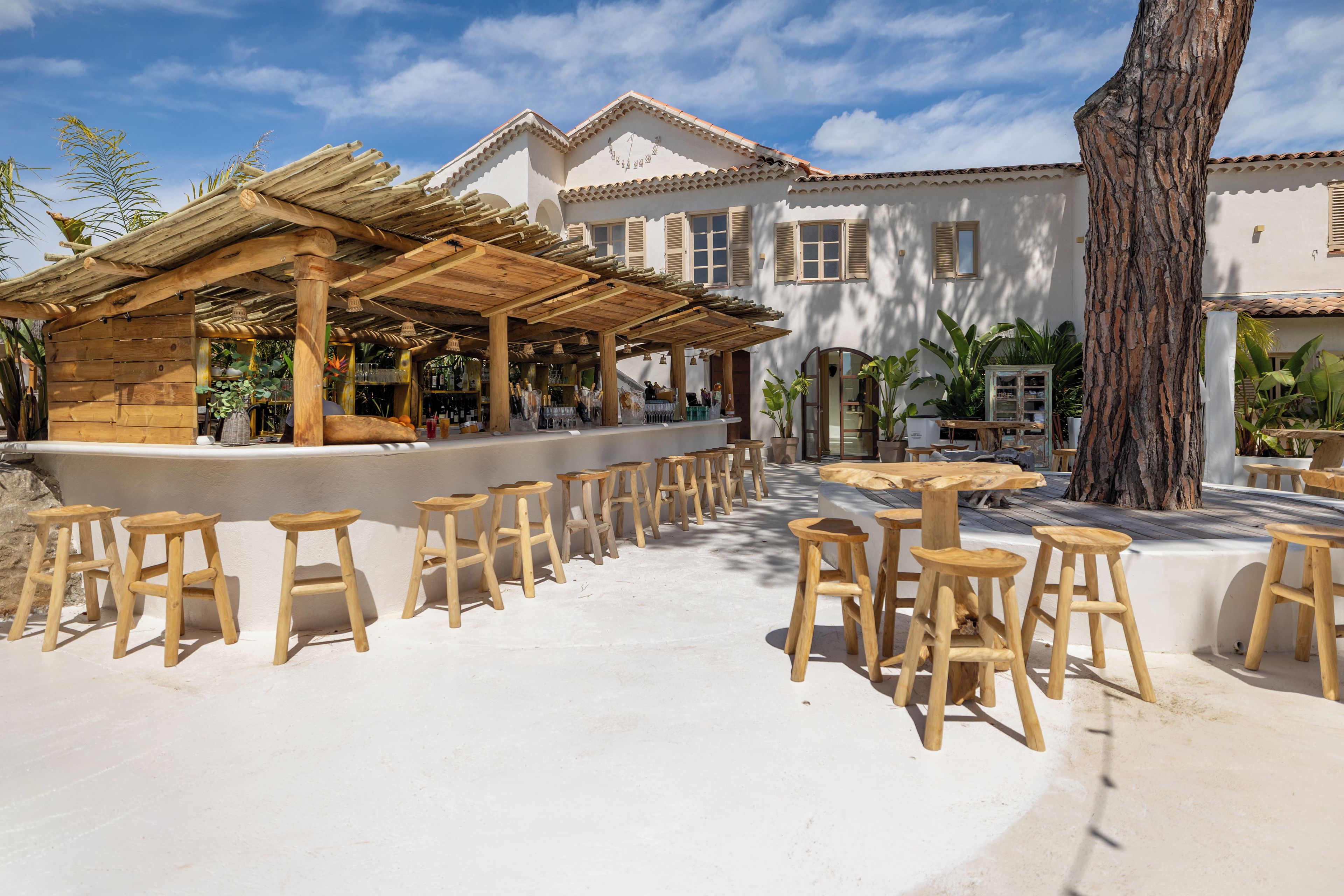 A patio area with wooden furniture and a bar.