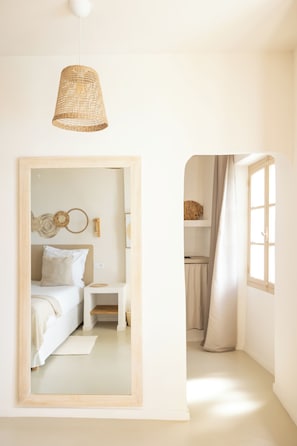 Quarto com cama, mesa de cabeceira e espelho.
