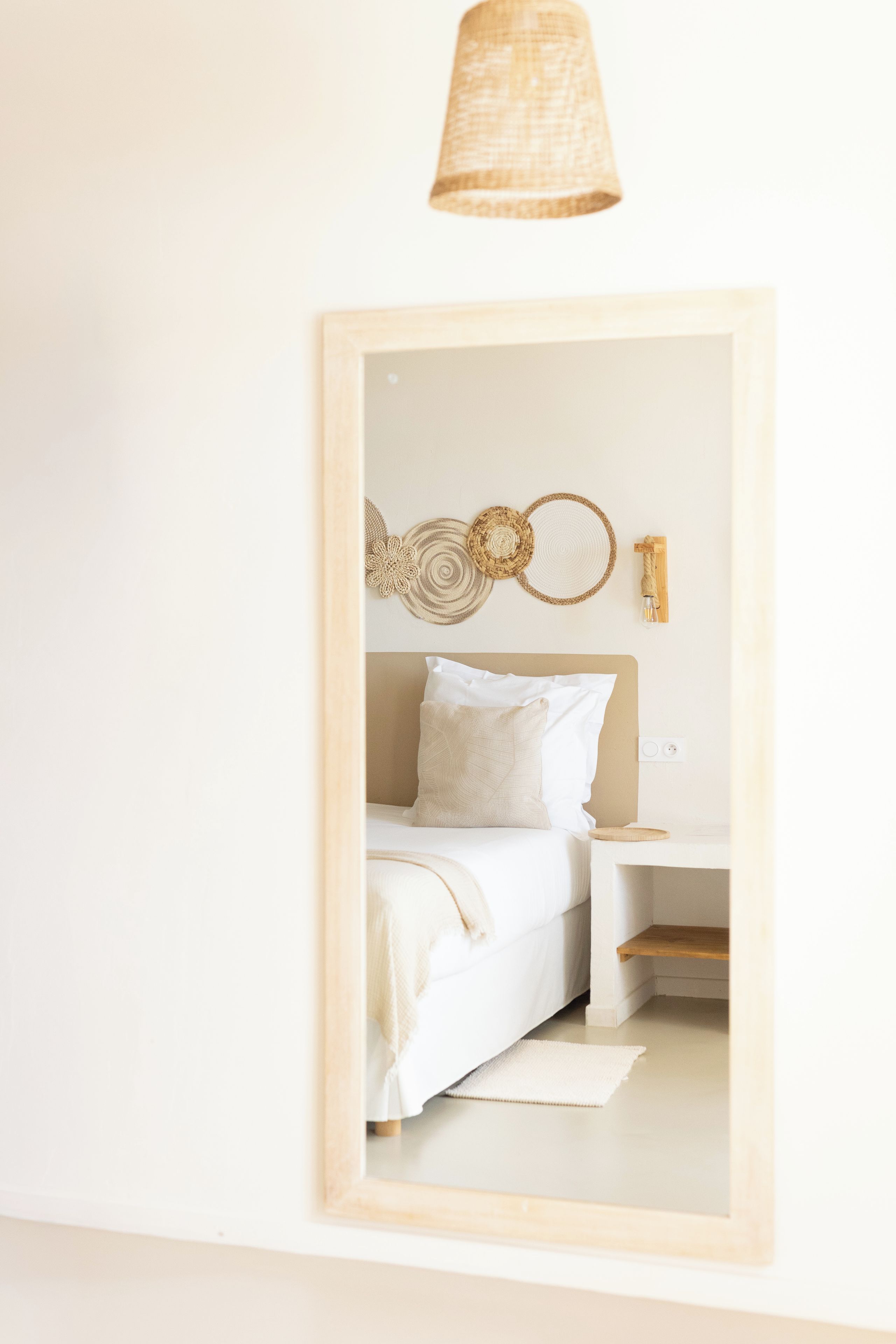 Un dormitorio con cama, mesita de noche y decoración en la pared.