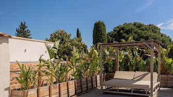 Un bain à remous avec une terrasse en bois et une pergola en bois dotée d’un banc.