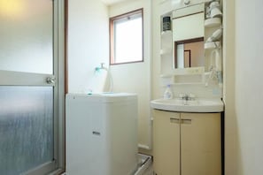 A small bathroom with a white toilet, a sink, and a mirror above it.