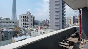A balcony with a view of a cityscape, including a prominent tower and various buildings. - Grace Mukojima Room 701 (Tokyo)