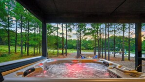 A hot tub with a view of a forested area and a basketball court. - The Pickleball Pines (Broken Bow)