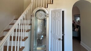 A grand staircase with white balusters and wooden steps, leading to an upper landing. - Beautiful Waterfront House with Pool sleeps 11 (Pass Christian)