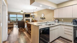 A kitchen with a dishwasher, a coffee maker, and a clock on the wall. - Lake Harbour on TRL For 6 (Hollister)