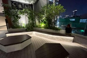 A rooftop terrace with seating, plants, and a view of the cityscape. - AXON Bukit Bintang Luxury Condo 3BED 2BATH (HIGH FLOOR) (Kuala Lumpur)