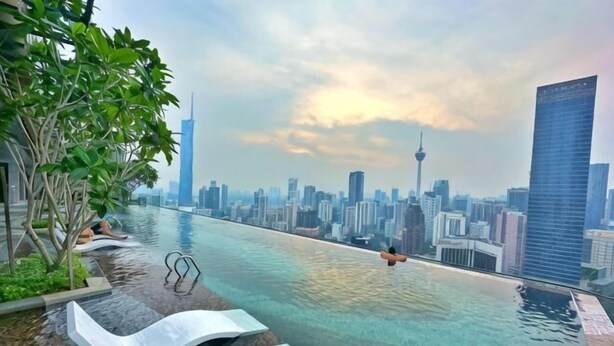 A swimming pool with a cityscape view, including a tall skyscraper and a tower. - AXON Bukit Bintang Luxury Condo 3BED 2BATH (HIGH FLOOR) (Kuala Lumpur)