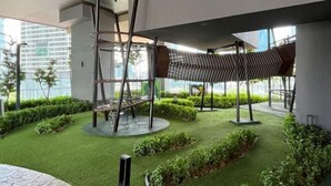 An outdoor area with artificial grass, metal structures, and greenery. - AXON Bukit Bintang Luxury Condo 3BED 2BATH (HIGH FLOOR) (Kuala Lumpur)