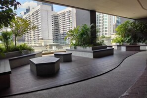 A rooftop terrace with modern seating and planters, offering views of surrounding high-rise buildings. - AXON Bukit Bintang Luxury Condo 3BED 2BATH (HIGH FLOOR) (Kuala Lumpur)