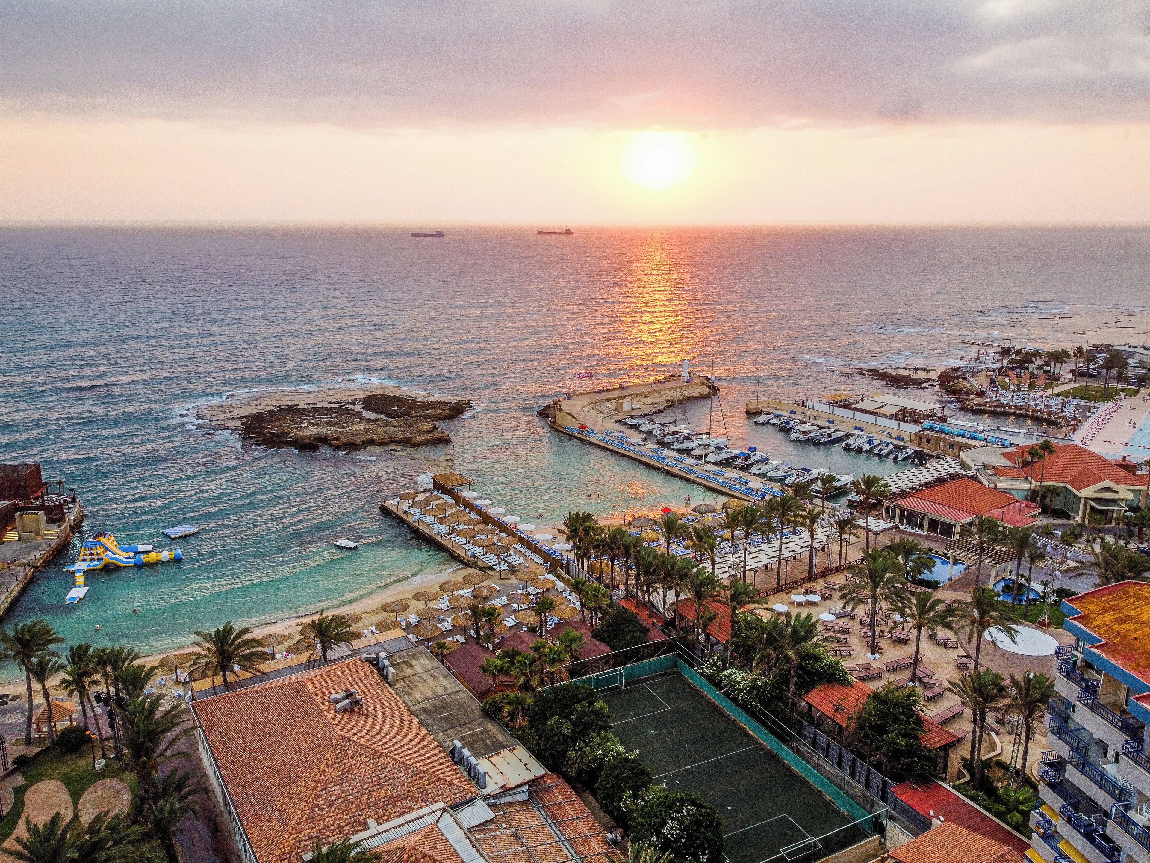 Un complejo turístico frente al mar, con puerto deportivo, playa y cancha de tenis.