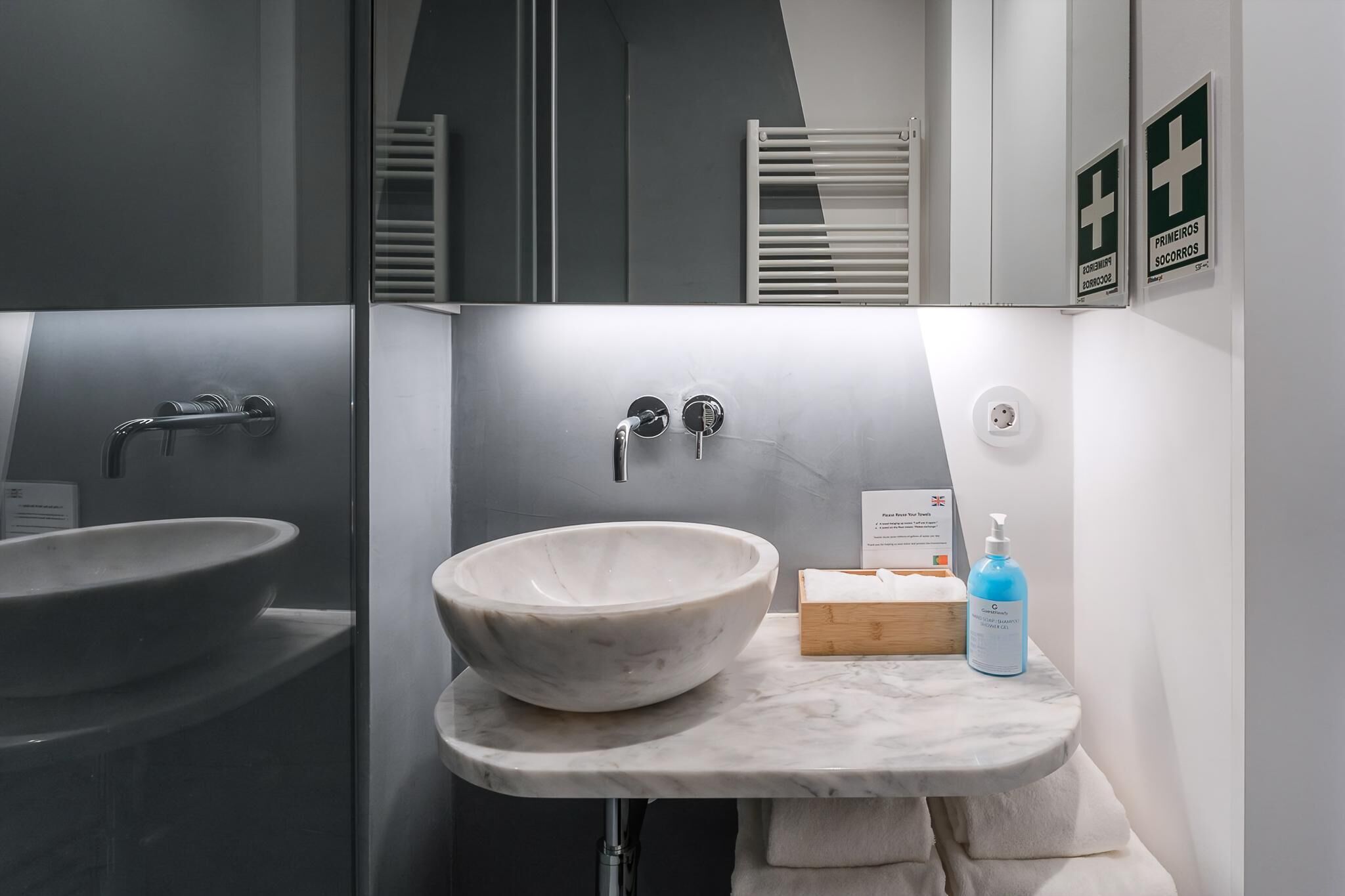 Une salle de bain moderne avec un grand lavabo en marbre, un miroir et un porte-serviettes.