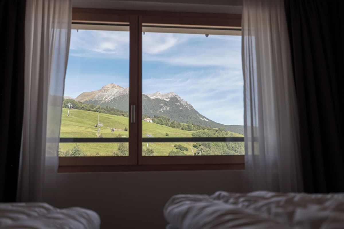 Ein Zimmer mit einem großen Fenster und Blick auf eine Berglandschaft.