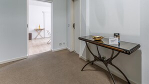 A hotel lobby with a glass-top table, a welcome sign, and a door leading to another room. - Guestready - Gold Leaf (Porto)