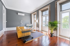 Un salon moderne avec un canapé, une petite table, une lampe et une plante en pot.