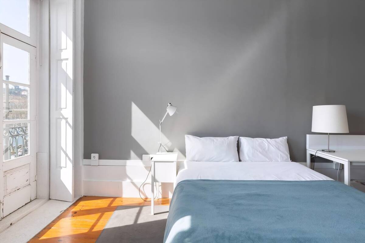 Une chambre d’hôtel avec un lit, des tables de chevet, une lampe et une vue par la fenêtre.