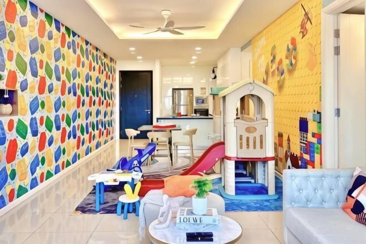Uma sala de estar moderna com uma parede colorida abstrata, uma área de recreação e um sofá.