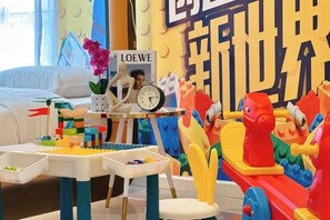 Ein Kinderspielbereich mit Bauklötzen, einem Spielzug und einem Tisch mit einer Uhr.