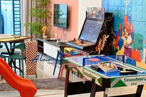 Ein Zimmer mit Pooltisch, Fernseher und einer LEGO-Spielzone.