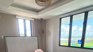 Un dormitorio moderno con una cama grande, una ventana con vistas y una lámpara de techo.