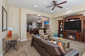 A living room with a fireplace, leather sofa, and a television.