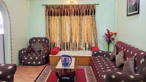 A living room with a sofa set, a chair, a coffee table, and a curtain. - Ojas Home Bharatpur (Bharatpur)
