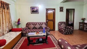 A living room with a sofa, armchair, and a small table with a tray. - Ojas Home Bharatpur (Bharatpur)