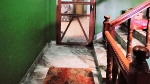 A staircase with wooden railings and a marble floor. - Ojas Home Bharatpur (Bharatpur)