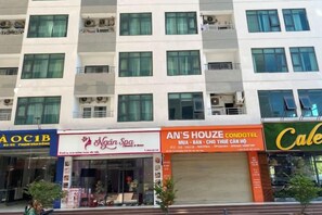 Un edificio de varios pisos con diversos establecimientos comerciales en la planta baja, como un spa, un hotel y una cafetería.