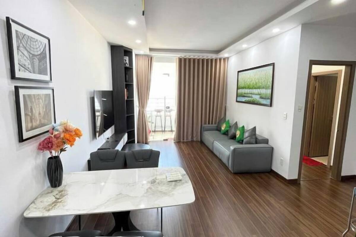 A modern living room with a dining table, sofa, and TV.