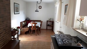 Une cuisine équipée d’une cuisinière, d’une table à manger, de chaises et d’un mur en briques.