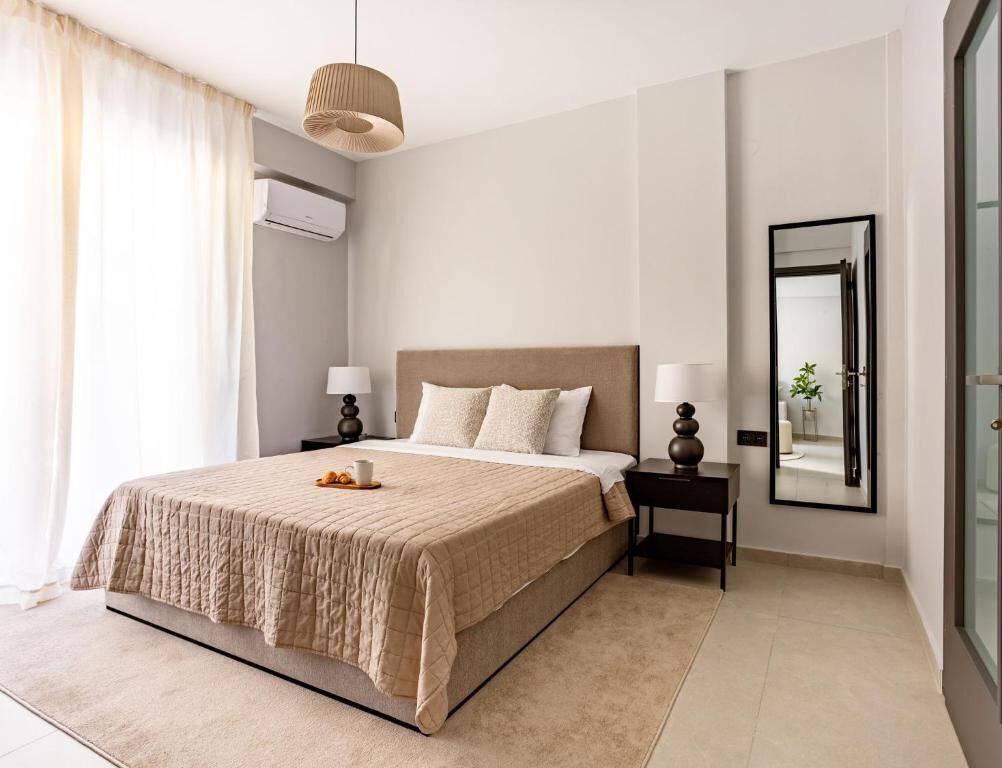 Une chambre à coucher moderne avec un grand lit, des lampes de chevet, un miroir et une vue sur l’extérieur.