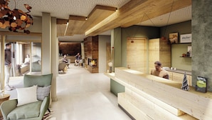 A modern hotel lobby with a reception desk, seating area, and a fireplace.