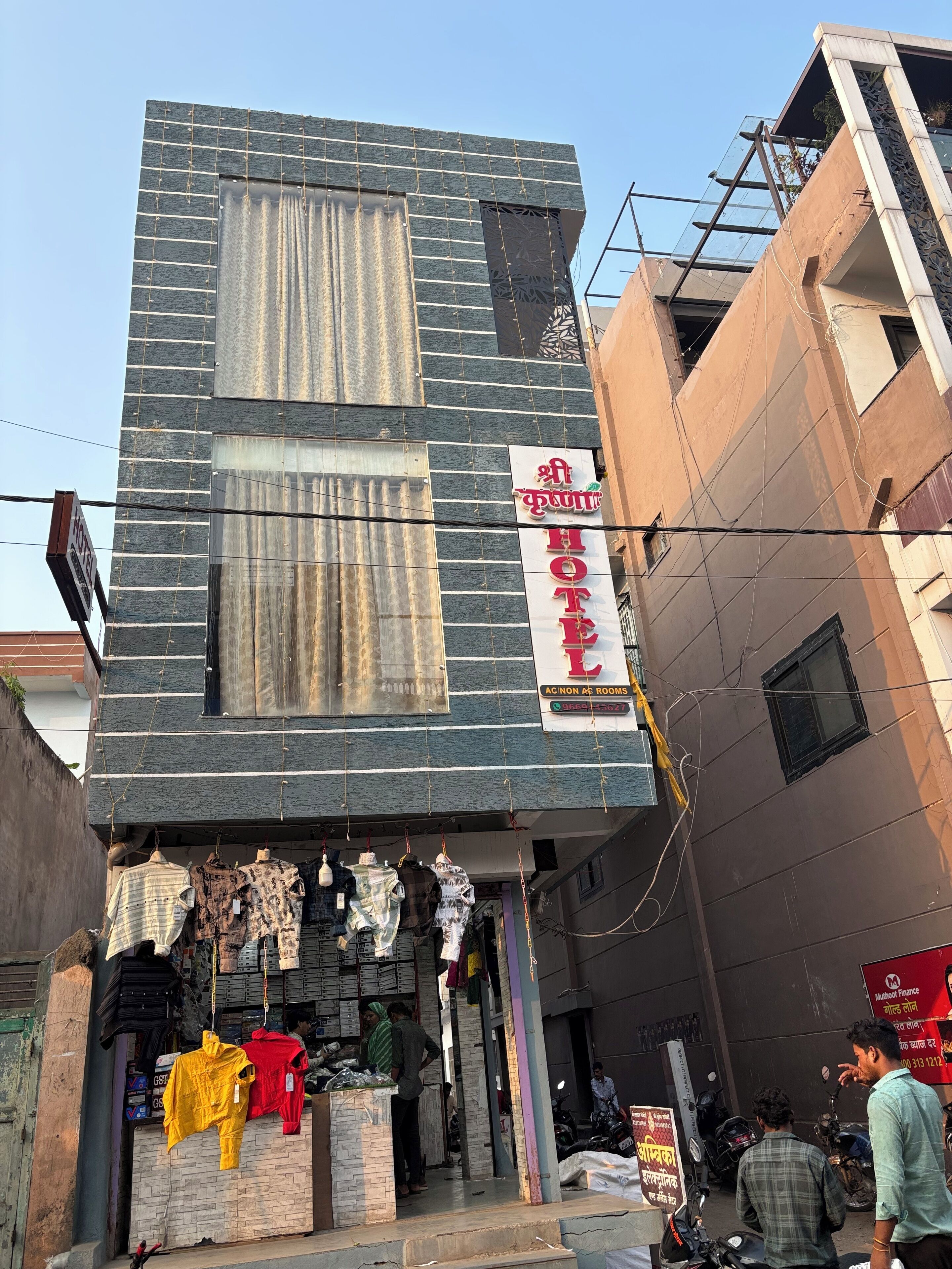 Un hôtel avec une enseigne indiquant « HÔTEL » et « CHAMBRES CLIMATISÉES ACONIC ».